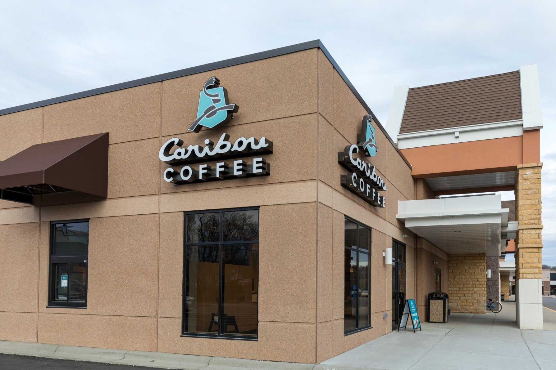 Exterior of Caribou Coffee retail addition showing storefront facade and entry canopy, constructed by Rice Companies