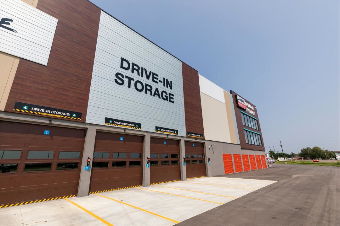 Row of drive‑in storage bays with overhead doors and clear site circulation at U‑Haul facility, constructed by Rice Companies.