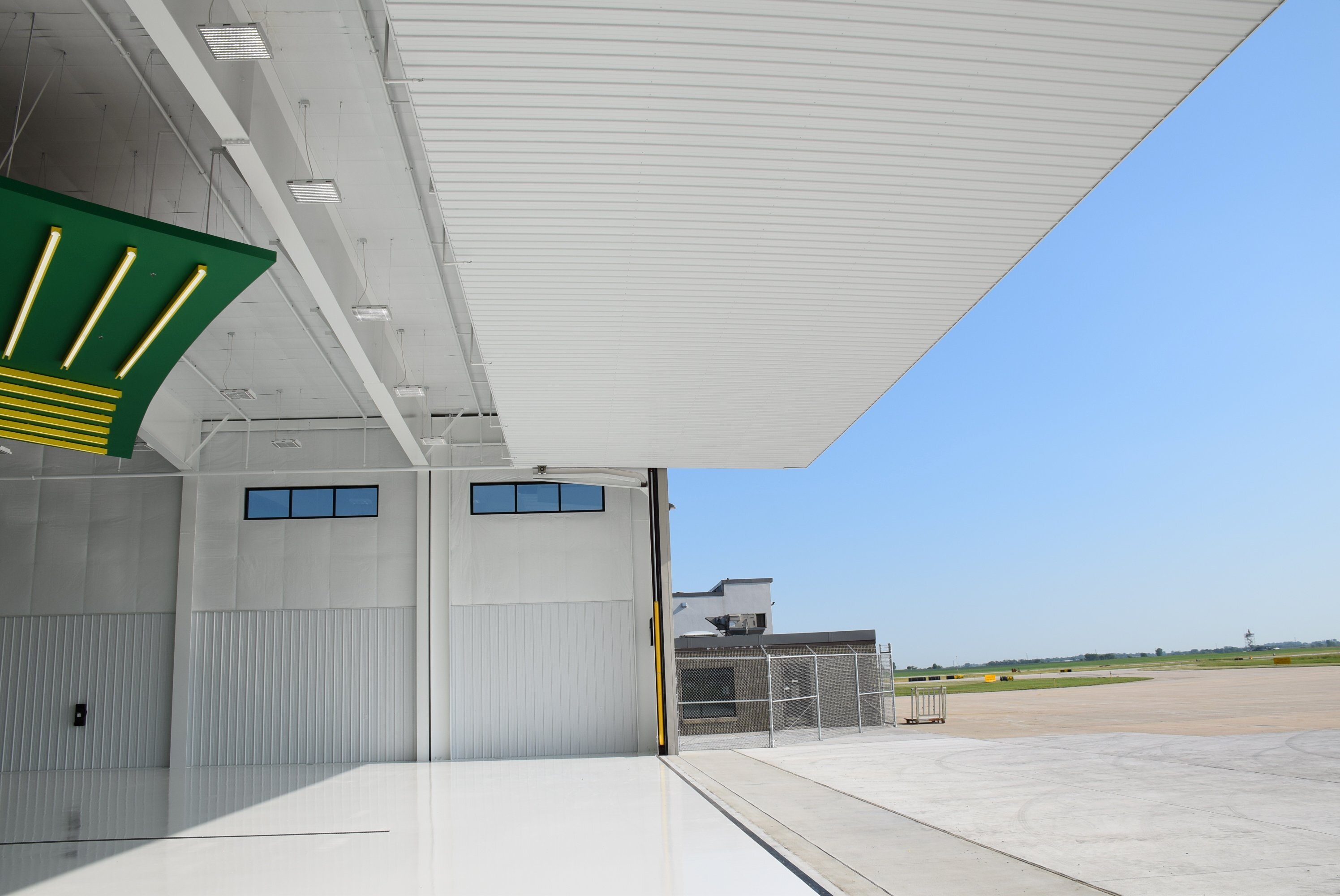 Site view of aircraft hangar facility showing hangar door opening and apron access, constructed by Rice Companies