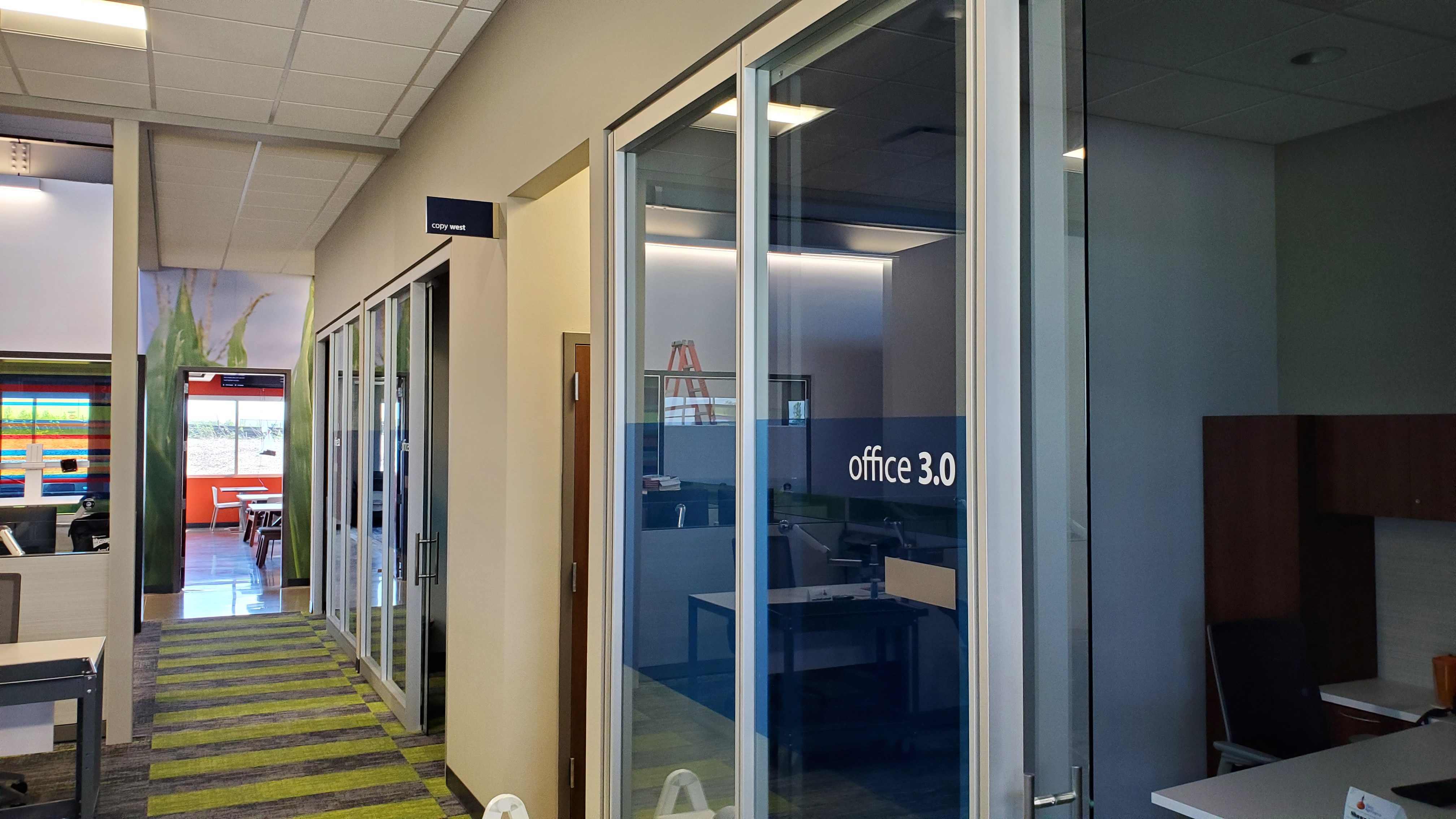 Interior hallway of Rabo AgriFinance office with glass‑front offices and modern finishes, constructed by Rice Companies