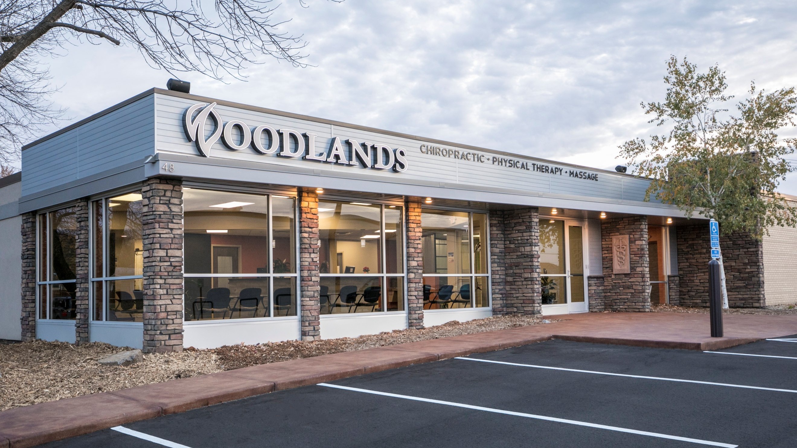Exterior of chiropractic and physical therapy clinic with updated storefront and stone columns, constructed by Rice Companies